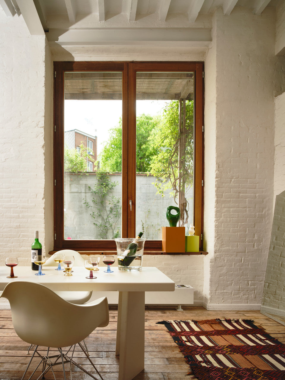 dining table in front of a window filled with wineglasses with blue colored stems
