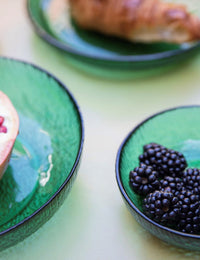 emerald green glass bowls and plates photographed close up