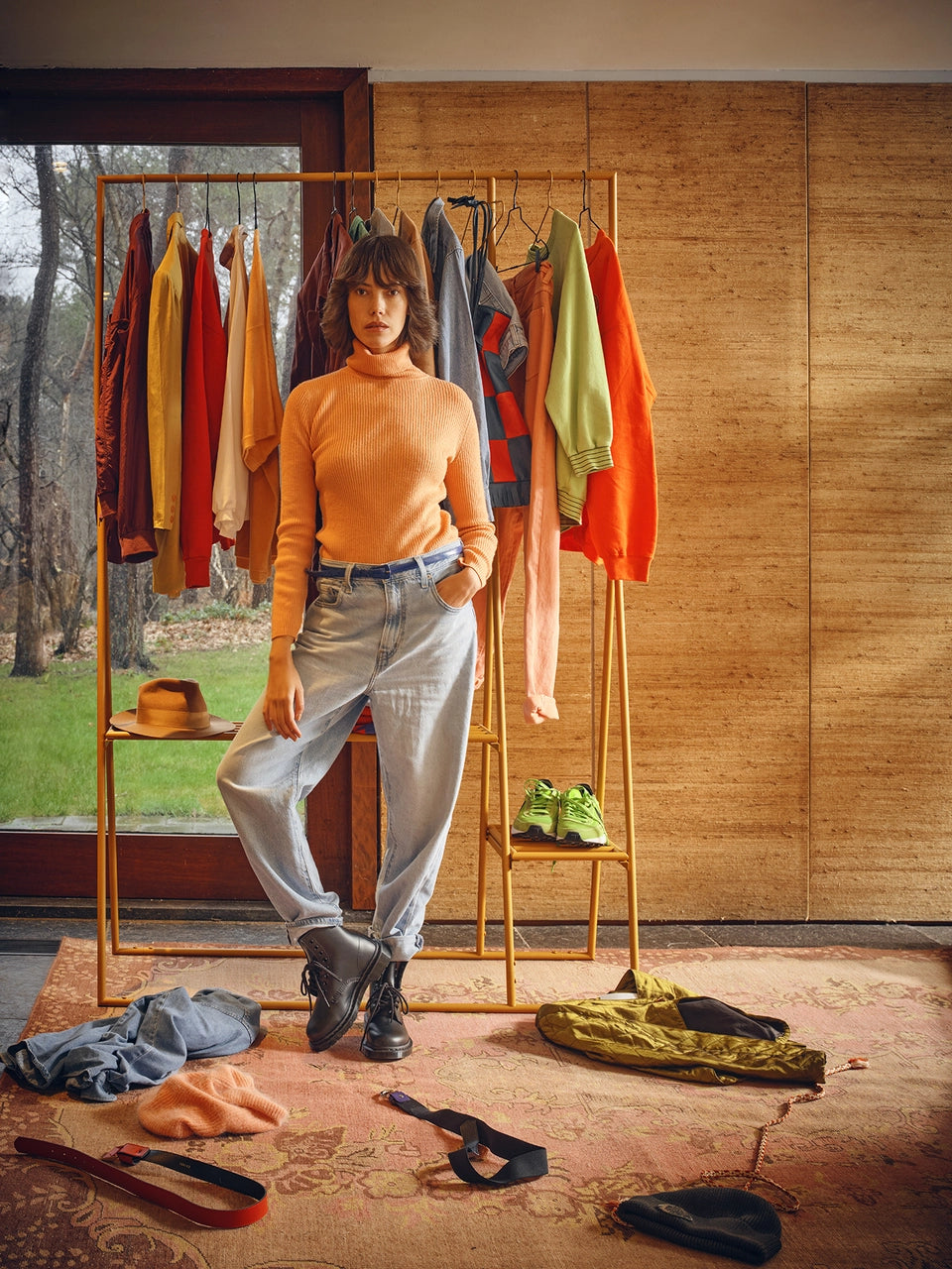 ginger orange metal open wardrobe rack in a room with clothes hanging and a woman standing in front of it