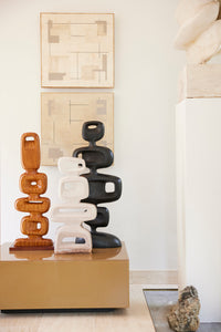 stoneware sculpture with reactive glaze finish next to wooden and black sculptures