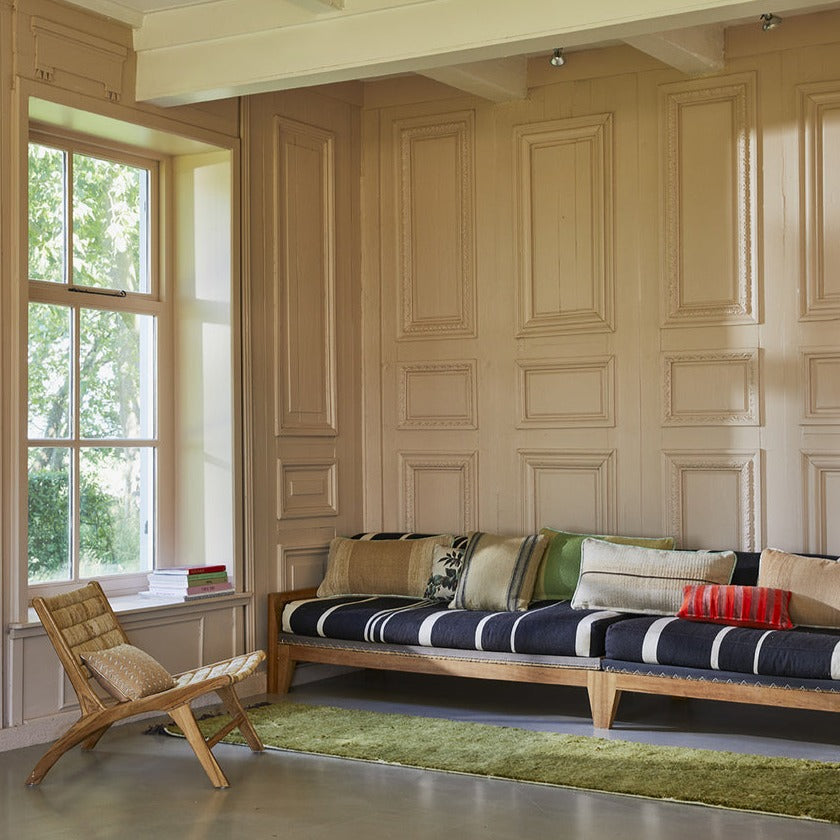 lounge sofa with dark blue and white striped seating with a variation of pillows in different materials and colors 