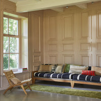 lounge sofa with dark blue and white striped seating with a variation of pillows in different materials and colors 