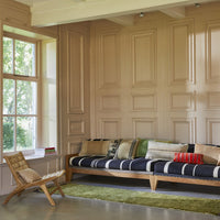 long wooden sofa with blue striped seating and a combination of woolen, linen and velvet pillows