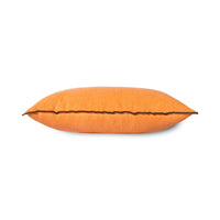 side view of orange linen lumbar pillow with brown cotton trim