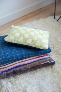 checkered cotton pillow in bright colors on a blue throw blanket