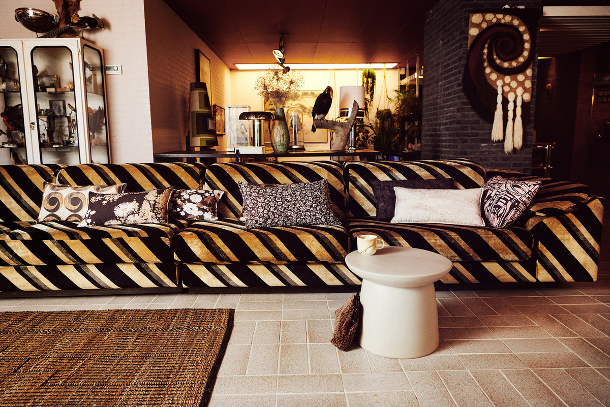 vintage inspired lumbar pillow with flower print on a velvet sofa with other pillows