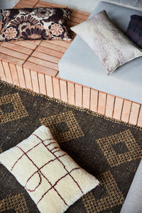 soft creamy pink lumbar pillow with blossom print on a bench