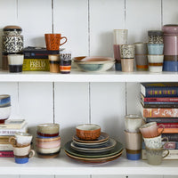 open shelving with ceramic plates, bowls and mugs and books