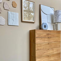 art panel on wall with faces from Peru and a framed paper art work