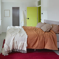 bedroom with yellow door and two different bedspreads in oranfge and white