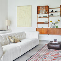 mid century modern style living room with dark beige and charcoal striped linen pillow on white boucle sofa