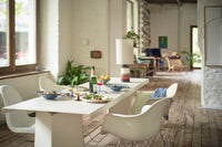 dning room with white chaires, a white table and retro style wineglasses with colored stems 