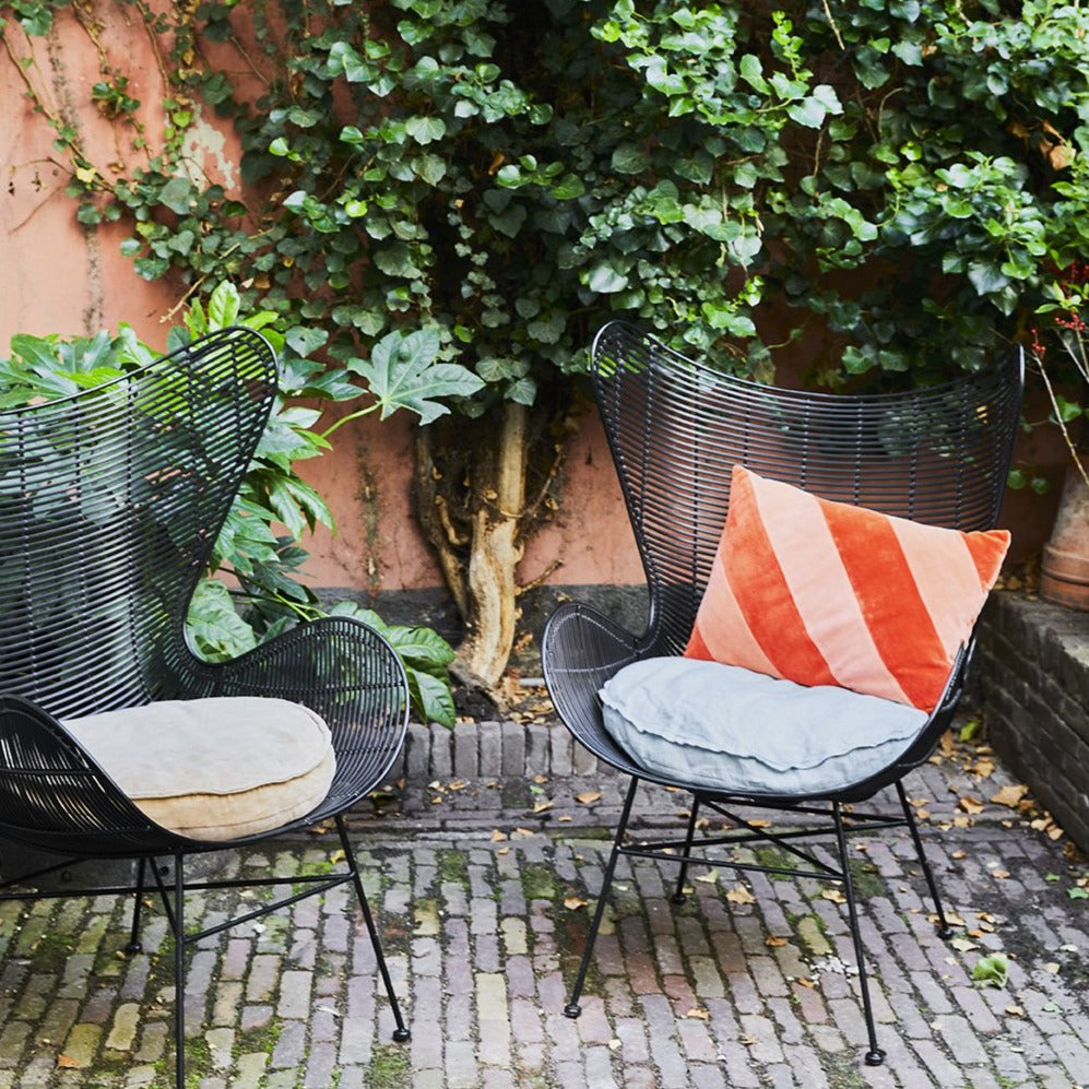 black egg chair with a blue linen round cushion