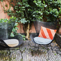 black egg chair with a blue linen round cushion