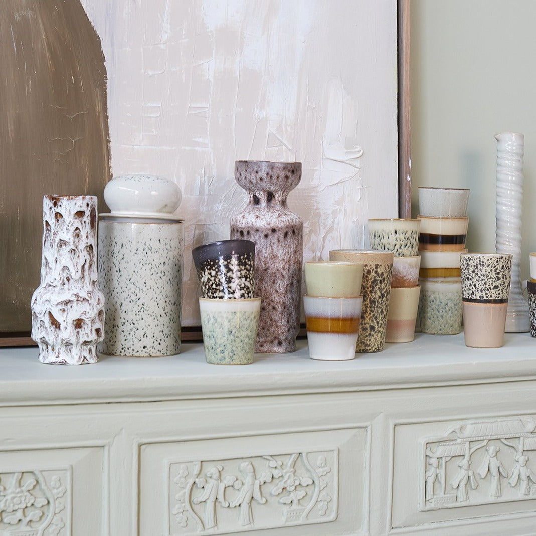 still-life with cermaic mugs, vases and storage jar with hail pattern 