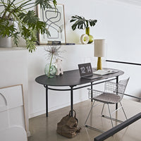 black desk with glass flower vase in shape of a circle