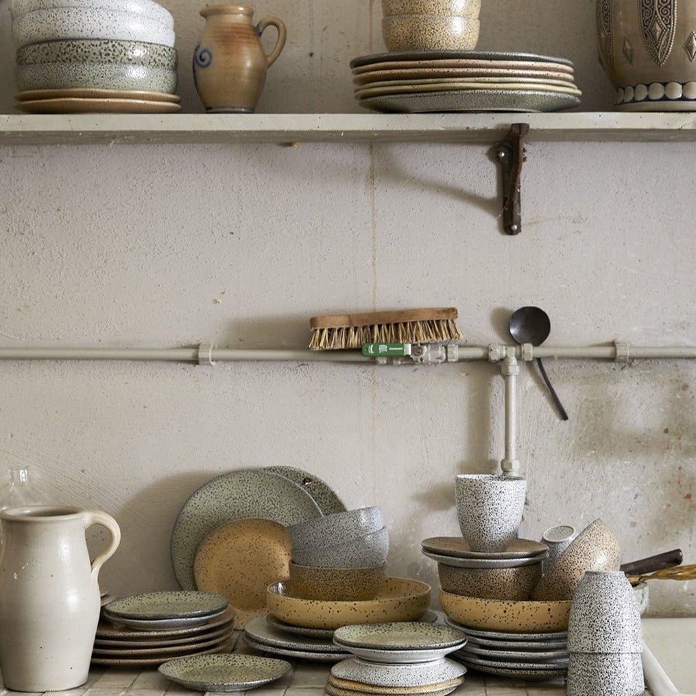 speckled ceramics waiting to be washed in the sink of an old school kitchen