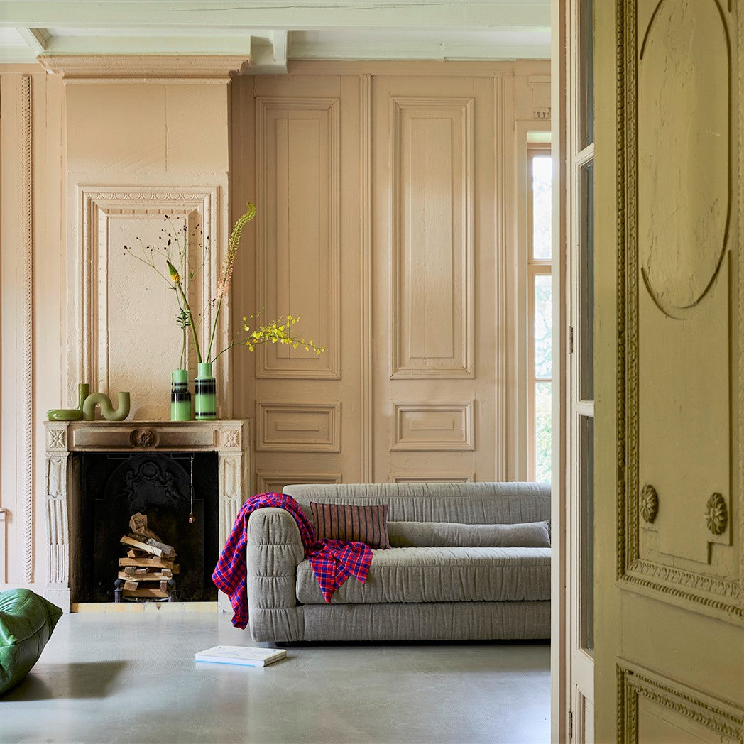 living room with large HKliving club couch and fire place with sculpture vases in green