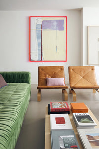 contemporary fresh looking living room with big abstract painting with neon pink frame, two lounge chairs and a pink linen lumbar pillow with red cotton trim