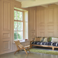 hand woven lounge chair in a room with a small accent pillow with silver accents