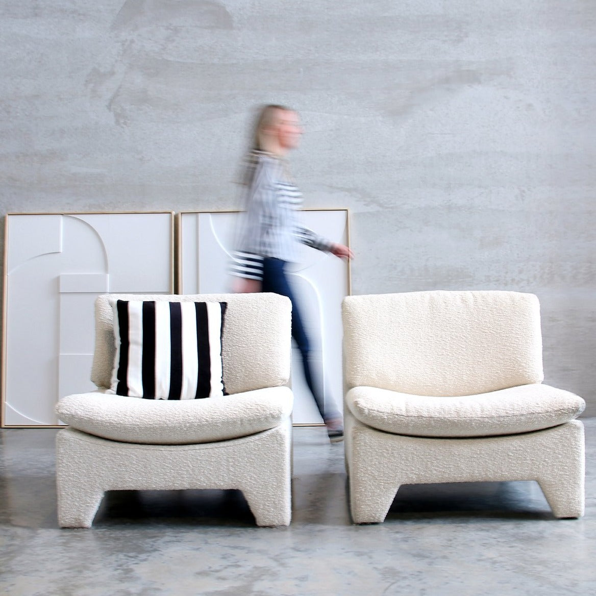 retro style lounche chairs in white cream color with paintings on wall