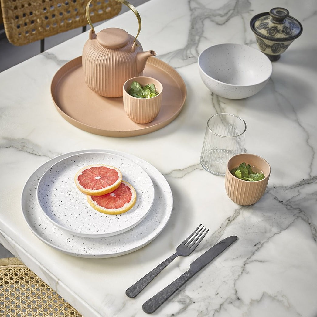 marble table with speckled ceramics and blush tray