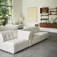 modern living room with white element sofa and open shelving with flower vases in various materials 