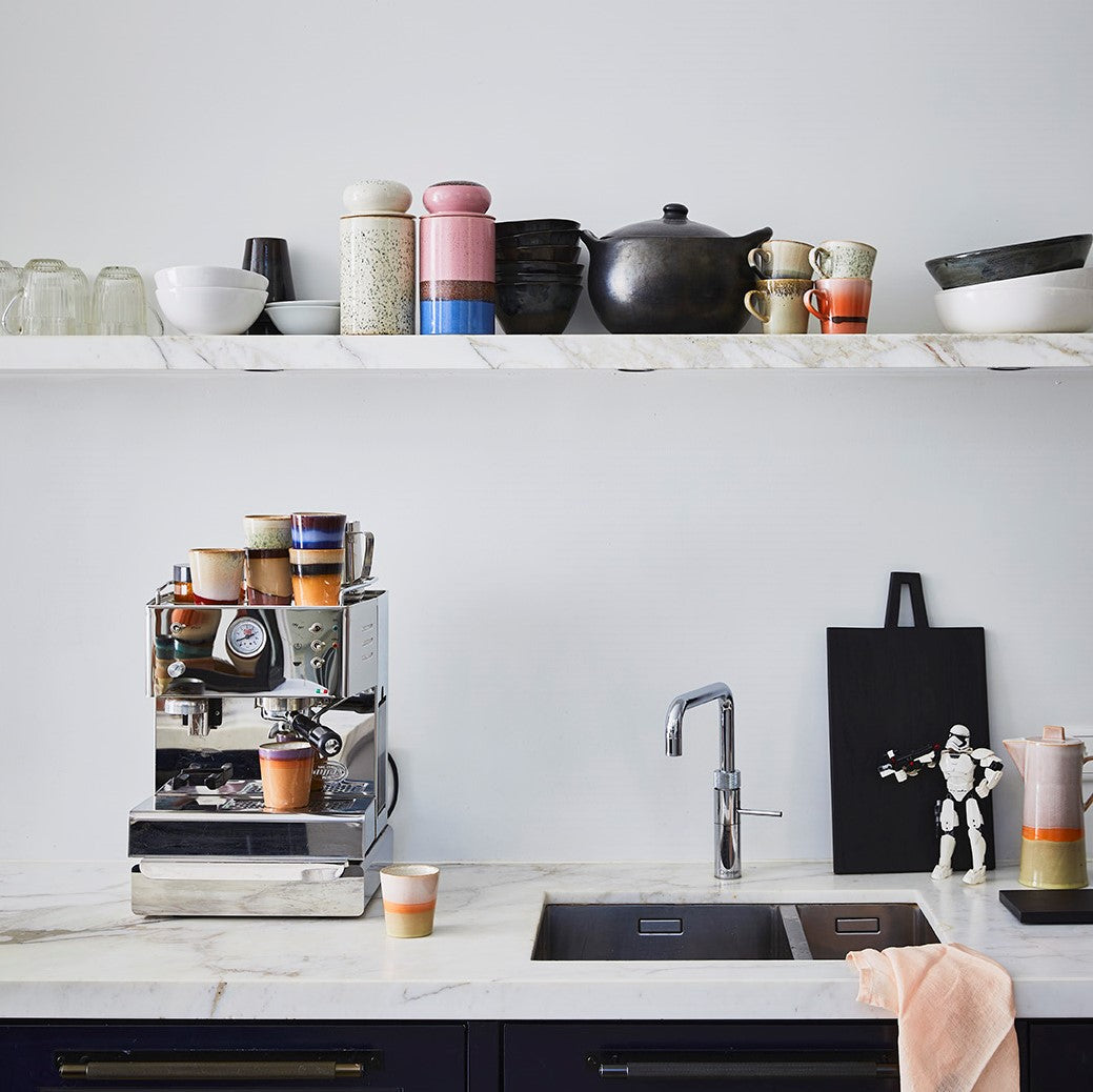 salmon colored linen napkin on counter top in open kitchen with colorful 70"s ceramics