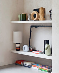 open shelving with blue green and brown vases as decoration