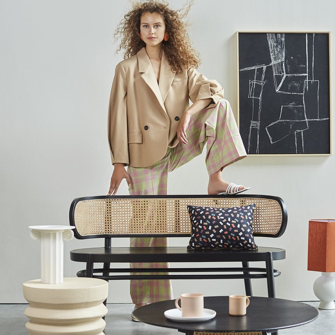 woman with curly hair in front of a black canvas with ash frame