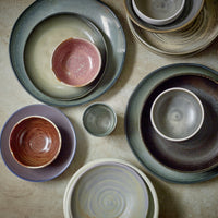 small porcelain bowls on top of side and dinner plates