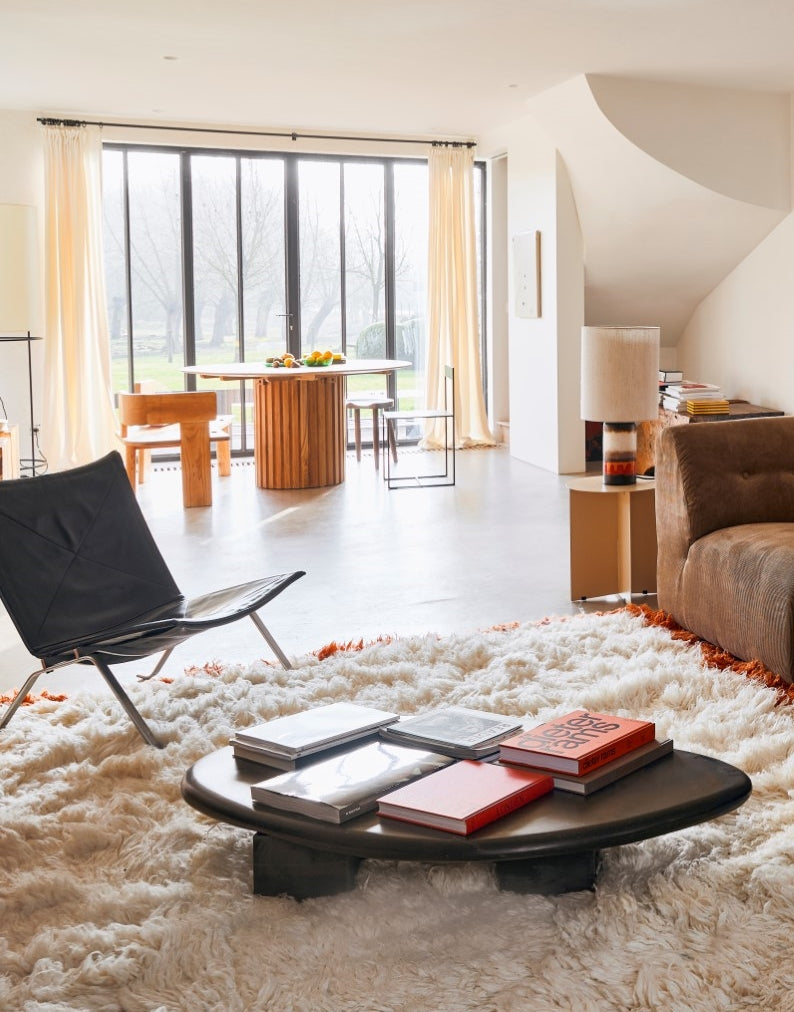 mid century modern style sitting and dining area with large round teak wooden dining table