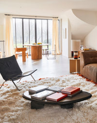 mid century modern style sitting and dining area with large round teak wooden dining table