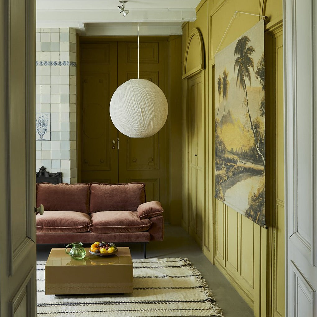 looking into a living room with a modern style wall hanging on the wall