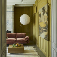 looking into a living room with a modern style wall hanging on the wall