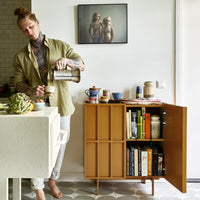 kitchen with open sideboard with books and storage jar on top