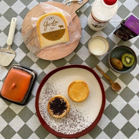 wooden spoon and kiwi in a bowl on a table with food